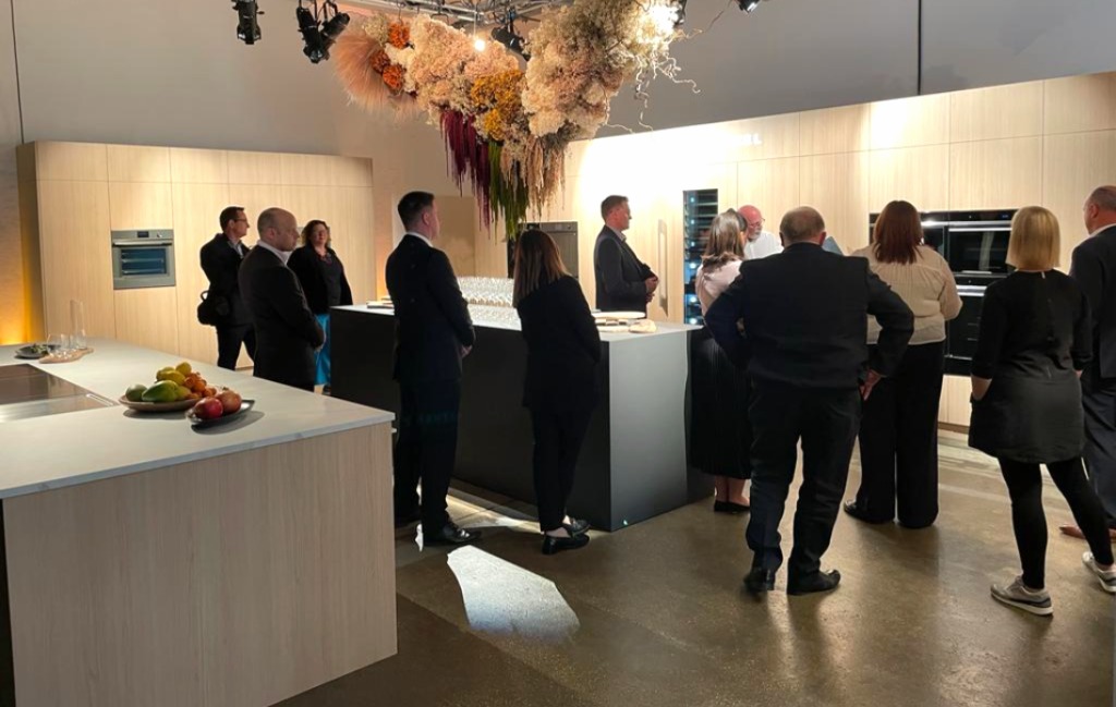 Guests at the Fisher & Paykel branded trade event in Shoreditch with oak kitchen displays and floral installation